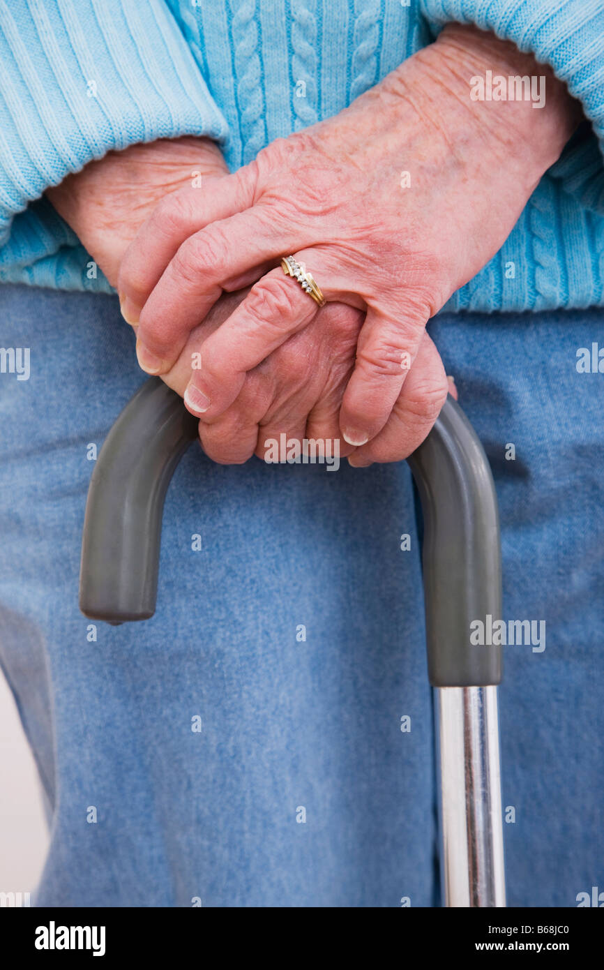 Close-up of woman's hands sur canne Banque D'Images