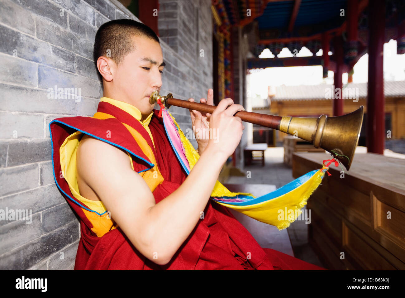 Jeune homme jouant de la corne dans un temple, Temple Da Zhao, Hohhot, Inner Mongolia, China Banque D'Images