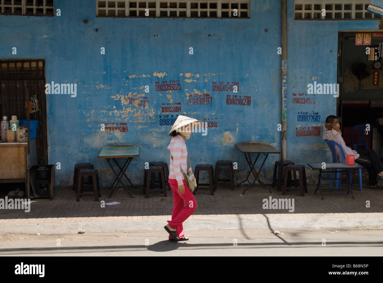 Femme portant un chapeau de paille conique à Ho Chi Minh Ville, Vietnam Banque D'Images