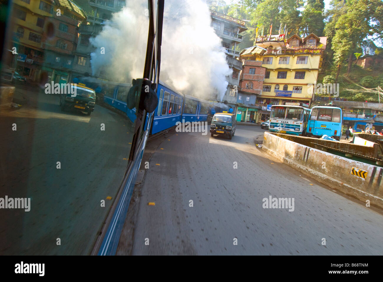 Le 'Petit Train' de la Darjeeling Himalayan Railway s'étend le long de la rue de Darjeeling, le mélange avec la circulation routière Banque D'Images