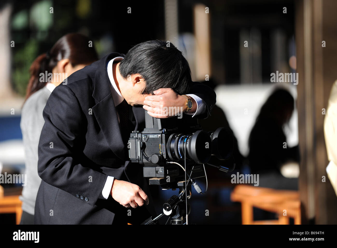 Un photographe de mariage japonais regarde à travers un appareil moyen format Banque D'Images