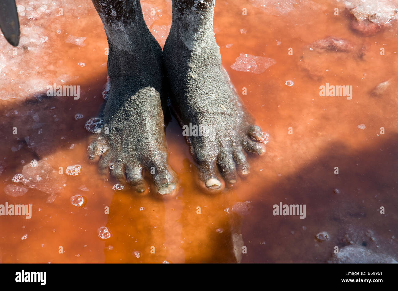 L'extraction de la soude au lac Natron en Tanzanie pieds d'un Masaï debout dans l'eau salée Banque D'Images