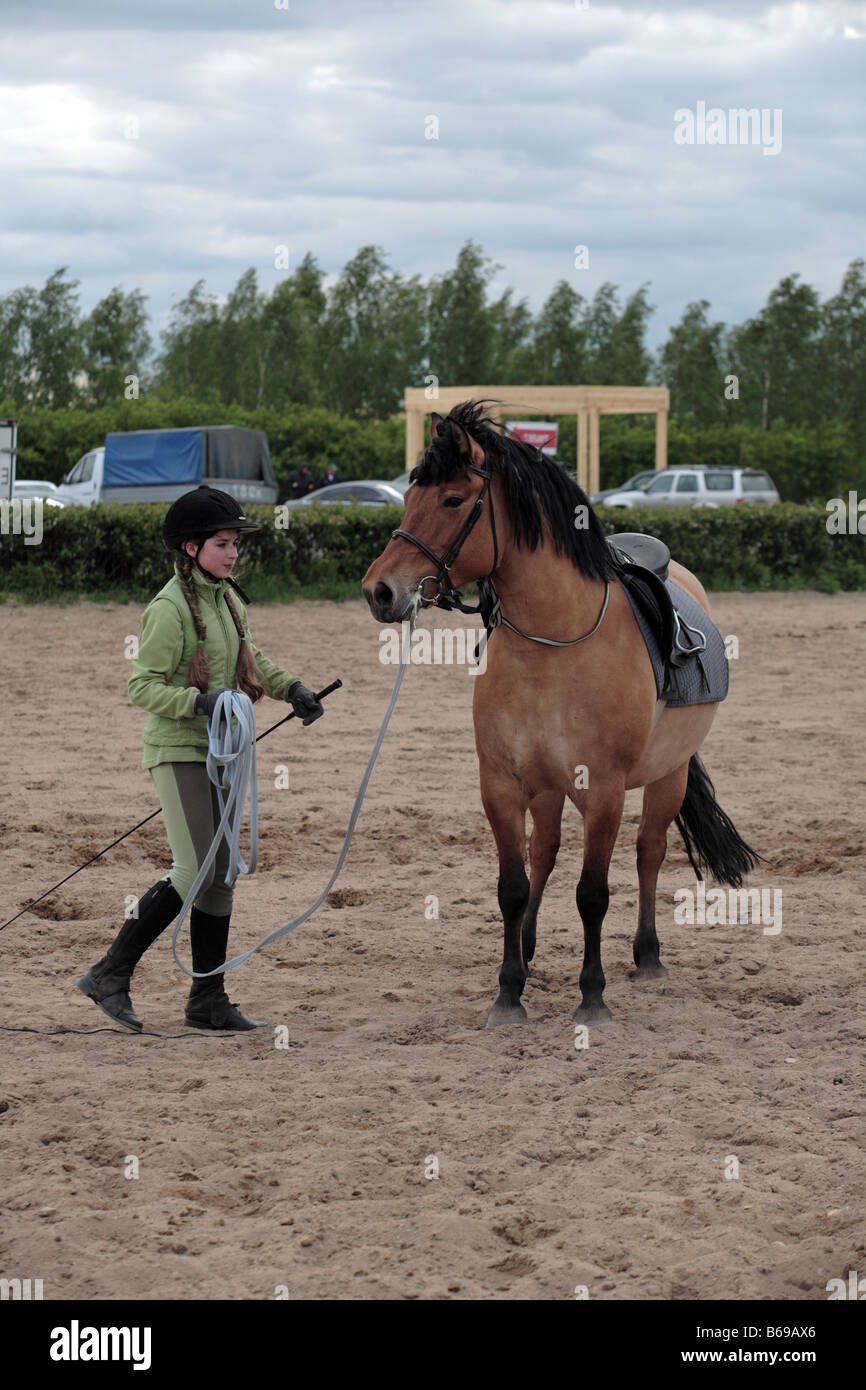 Dix ans, fille, prépare à monter à cheval dans un événement équestre Banque D'Images