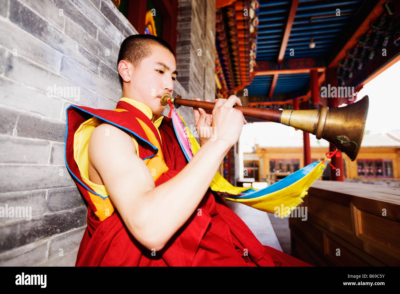 Jeune homme jouant de la corne dans un temple, Temple Da Zhao, Hohhot, Inner Mongolia, China Banque D'Images