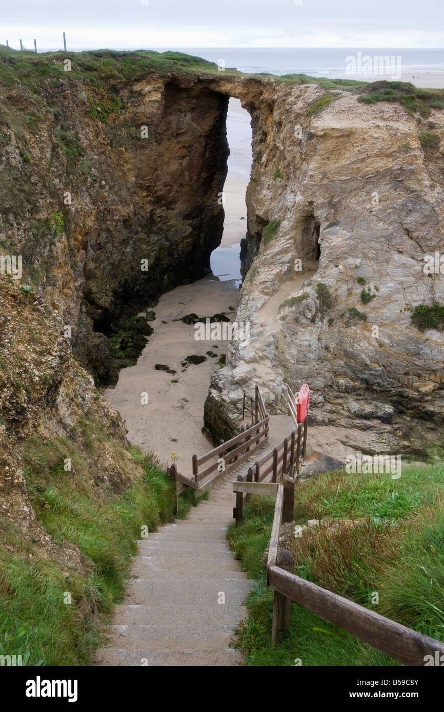 Longue série d'étapes menant jusqu'à une arche en pierre naturelle sur la côte de Cornouailles en Angleterre Banque D'Images