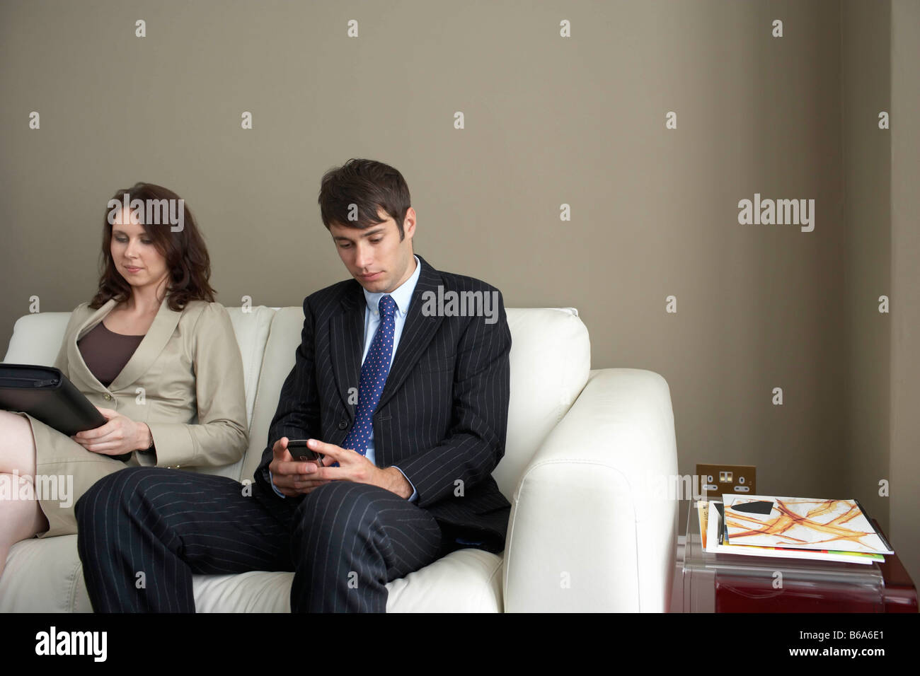 Businessman and woman sitting on sofa Banque D'Images