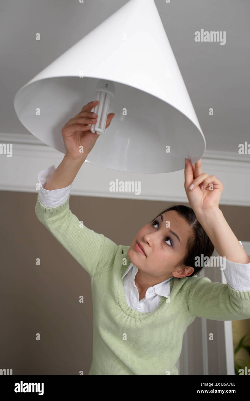 Femme changer lightbulb Banque D'Images
