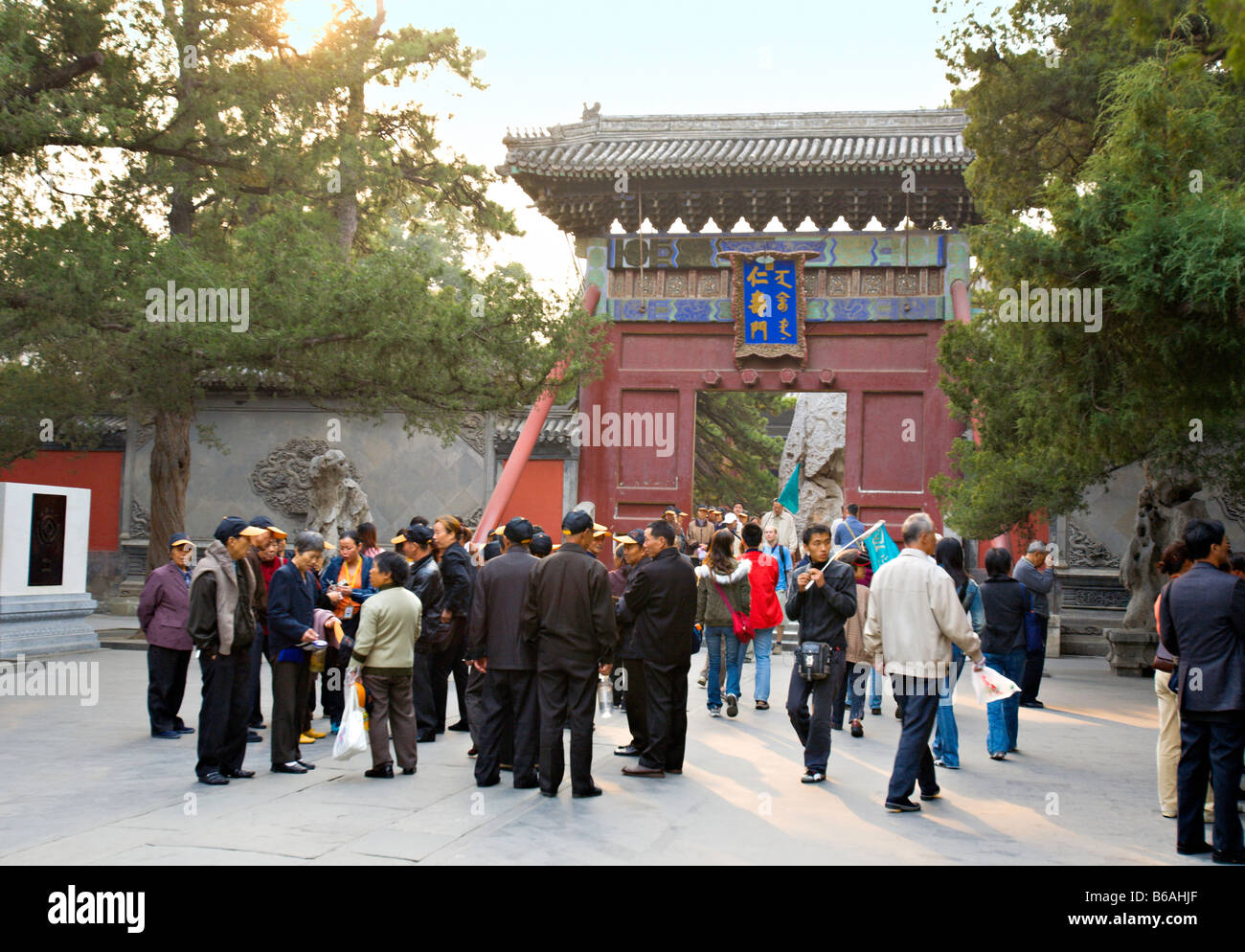 BEIJING CHINE groupe de voyageurs chinois portant des casquettes de baseball et guide suivant avec un drapeau dans le Palais d'été. Banque D'Images