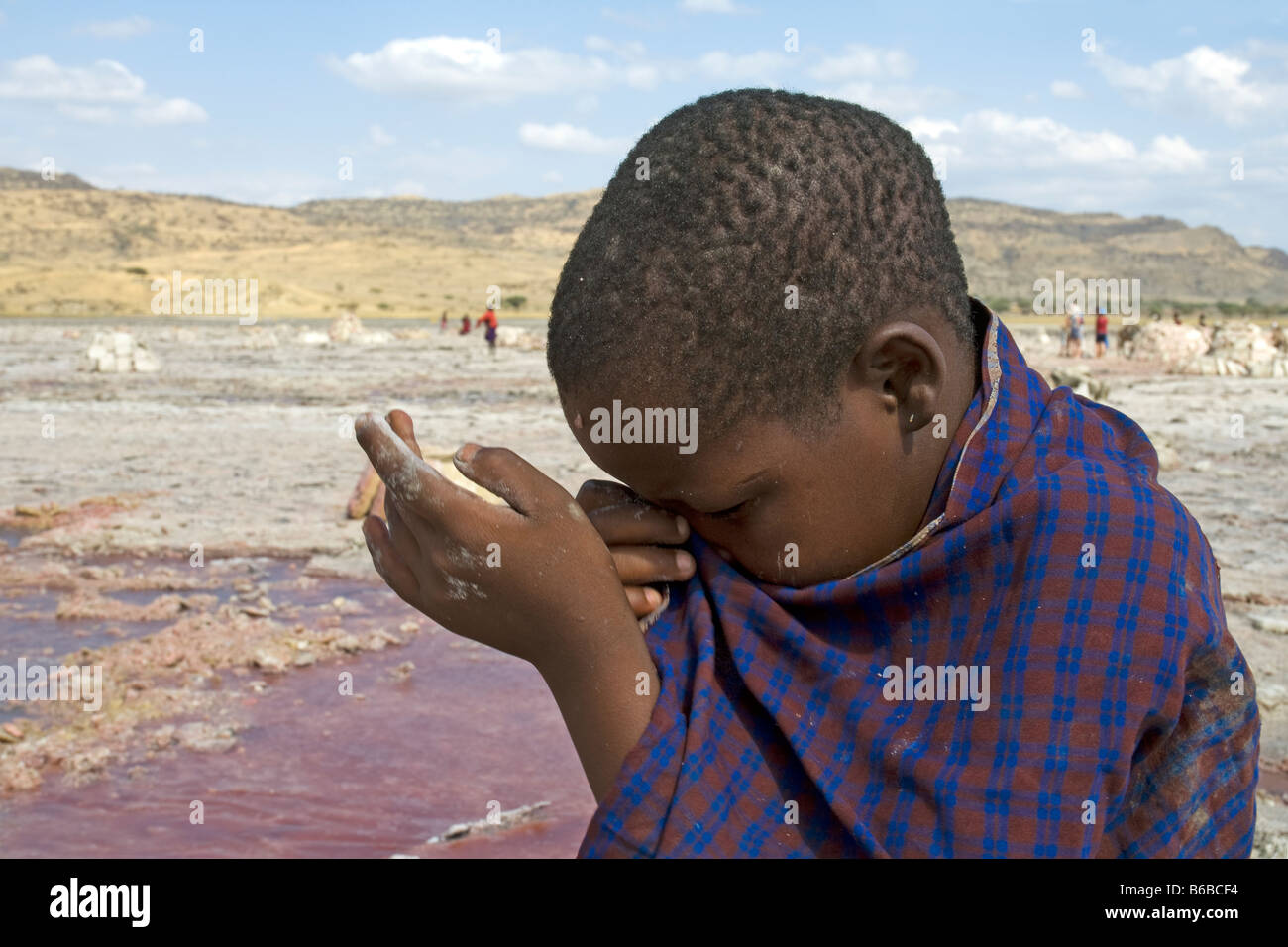 L'extraction de la soude au lac Natron en Tanzanie d'éclaboussures d'eau salée dans l'oeil d'une jeune fille travaillant dans la mine de sel Banque D'Images