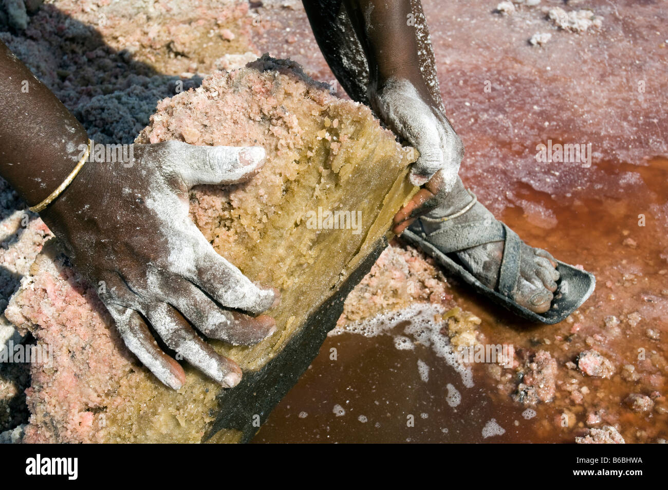 L'extraction de la soude au lac Natron en Tanzanie mains d'un masaï du levage d'une dalle de sel Banque D'Images