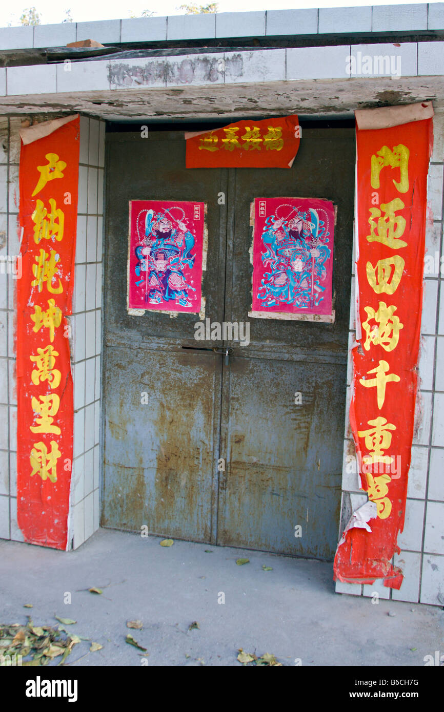 Chine Pékin Porte d'un hutong traditionnel maison avec panneaux rouges en caractères chinois mandarin Banque D'Images