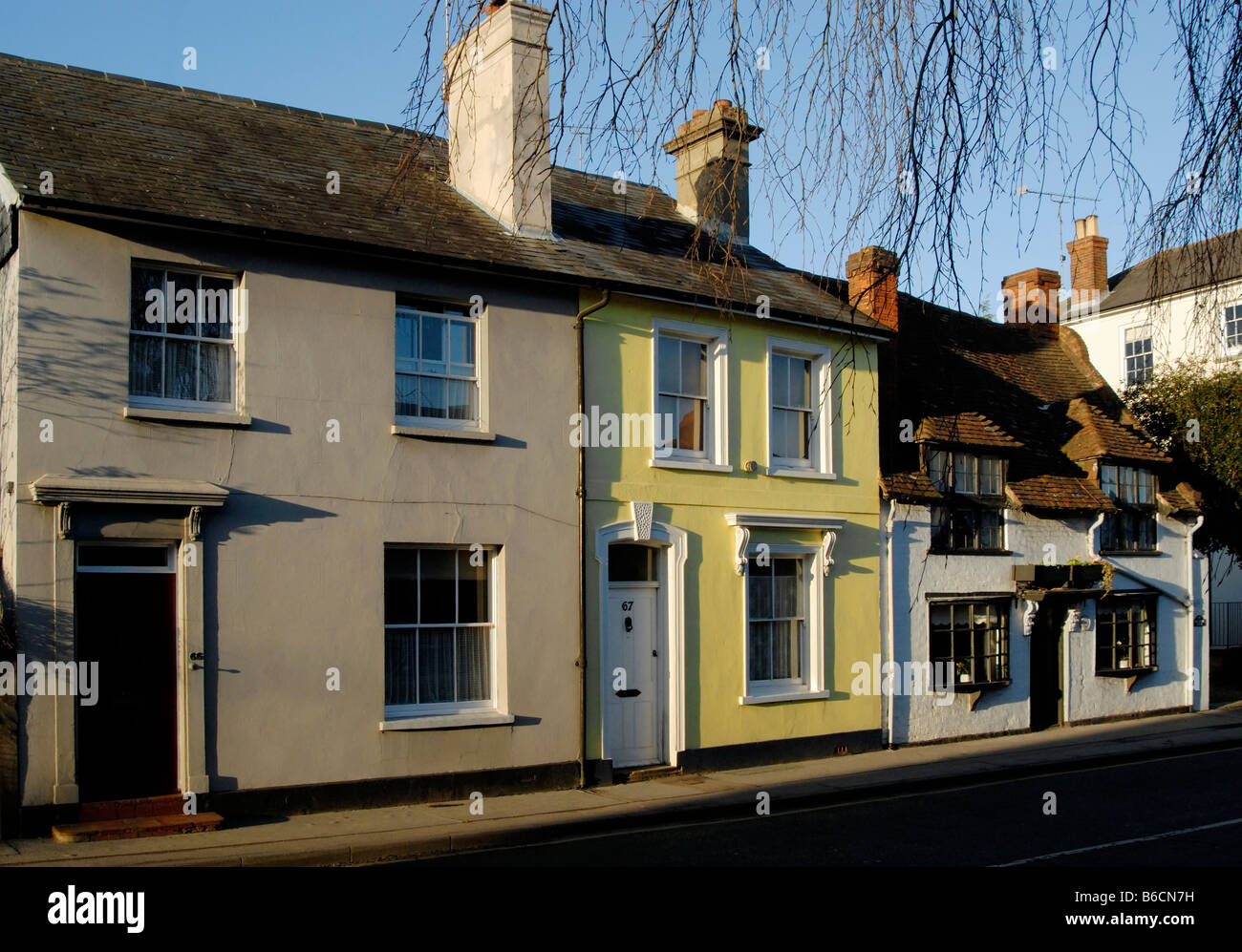 Au début du 17ème siècle et de cottages de style géorgien maison vernaculaire vue à travers les branches d'arbres, West Street, Farnham, Surrey, Angleterre Banque D'Images