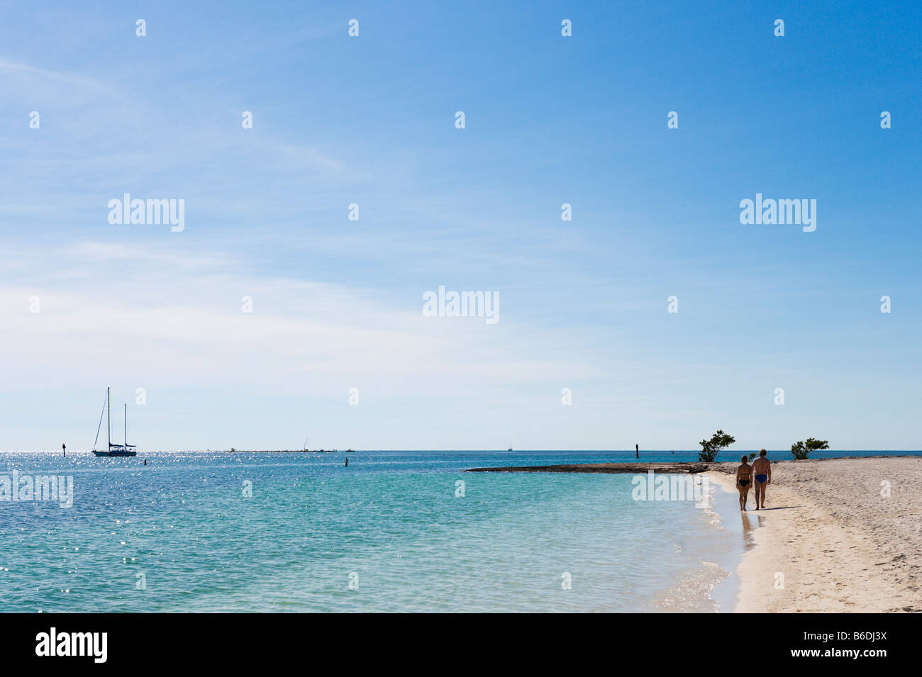 Couple en train de marcher sur la plage avec un yacht au loin, Sombrero Beach, Vaca Key, Marathon, Florida Keys Banque D'Images Couple en train de marcher sur la plage avec un yacht au loin, Sombrero Beach, Vaca Key, Marathon, Florida Keys Banque D'Images