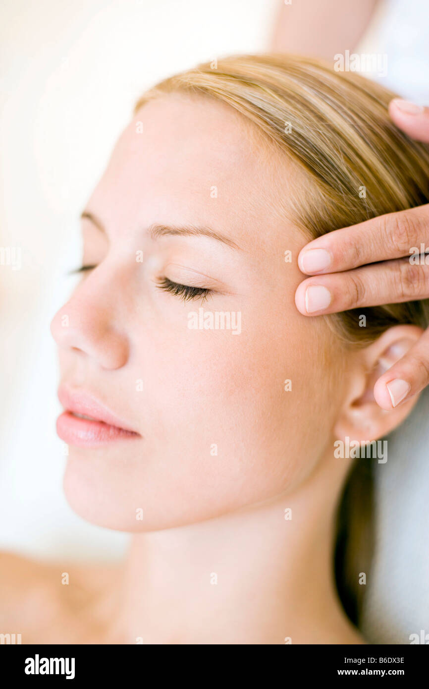 Woman receiving massage du temple qui peut soulager la douleur ou raideur musculaire en stimulant le flux sanguin à la zone affectée Banque D'Images