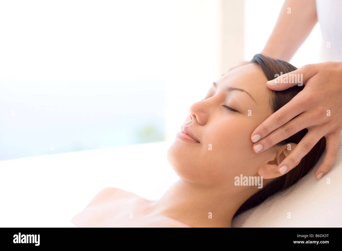 Woman receiving massage du temple qui peut soulager la douleur ou raideur musculaire en stimulant le flux sanguin à la zone affectée Banque D'Images