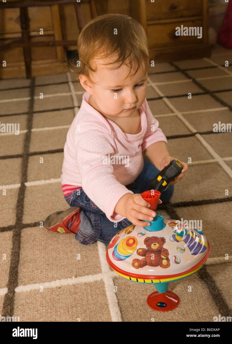 Un an bébé fille jouant avec toupie Banque D'Images