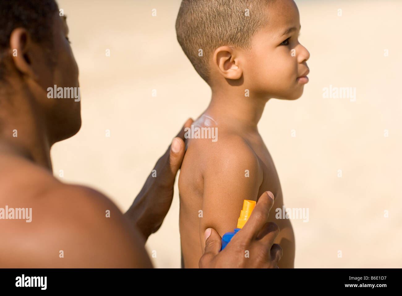 La protection contre le soleil. L'homme frotte la crème solaire crème sur la poitrine de son fils. Banque D'Images