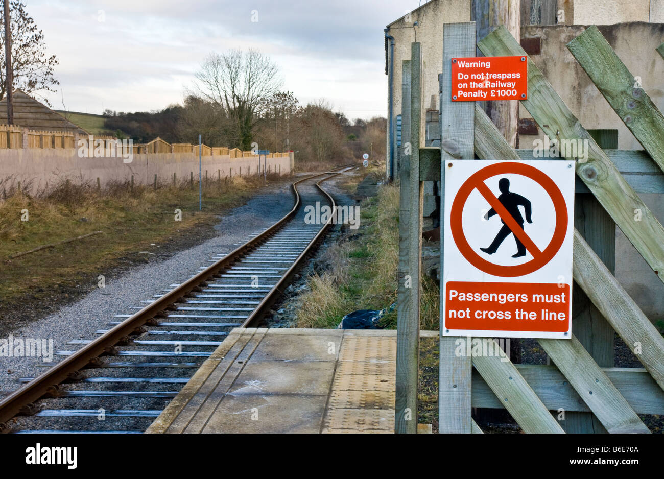 Ligne de chemin de fer avec des signes d'avertissement pour les piétons de ne pas s'aventurer sur la ligne. Banque D'Images