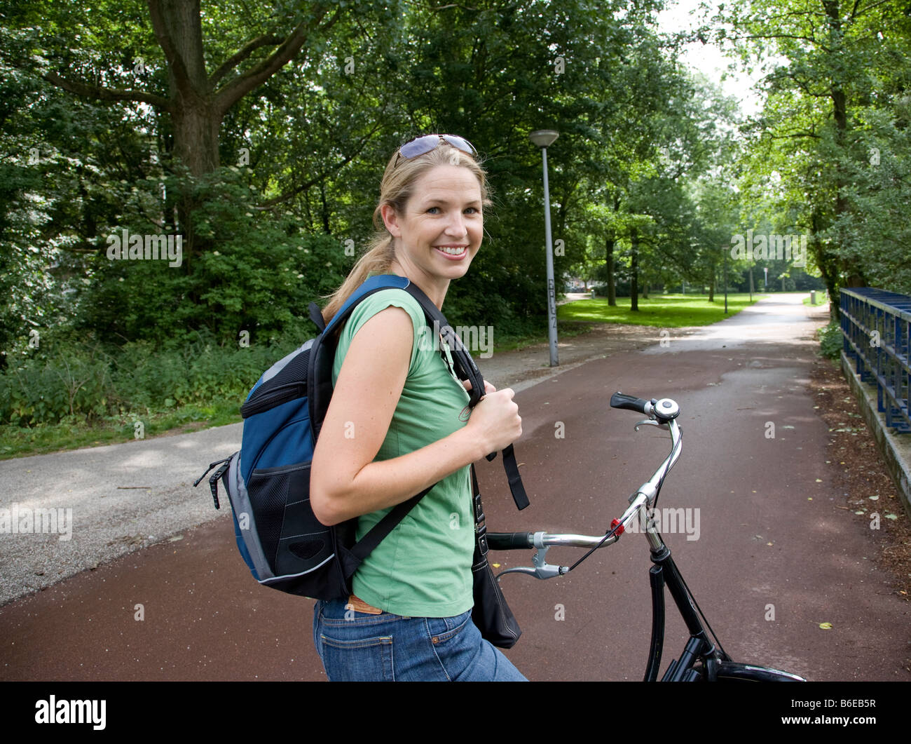 Une femme marque un temps sur un ressort en vélo à travers les parcs d'Amsterdam. Banque D'Images