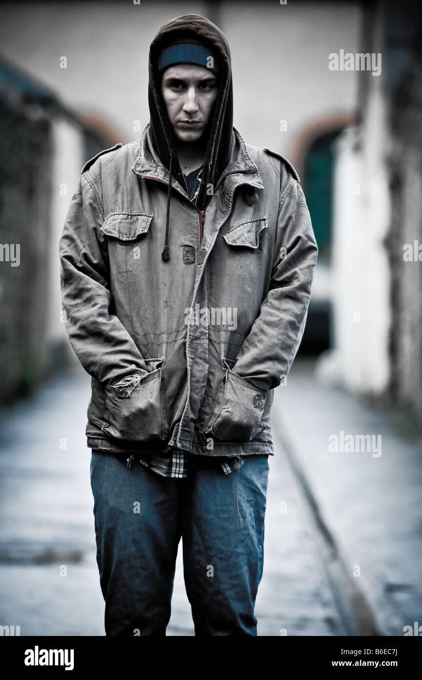 Jeune homme portant une veste seule et isolée dans une ruelle dans une ville, seul et misérable UK Banque D'Images