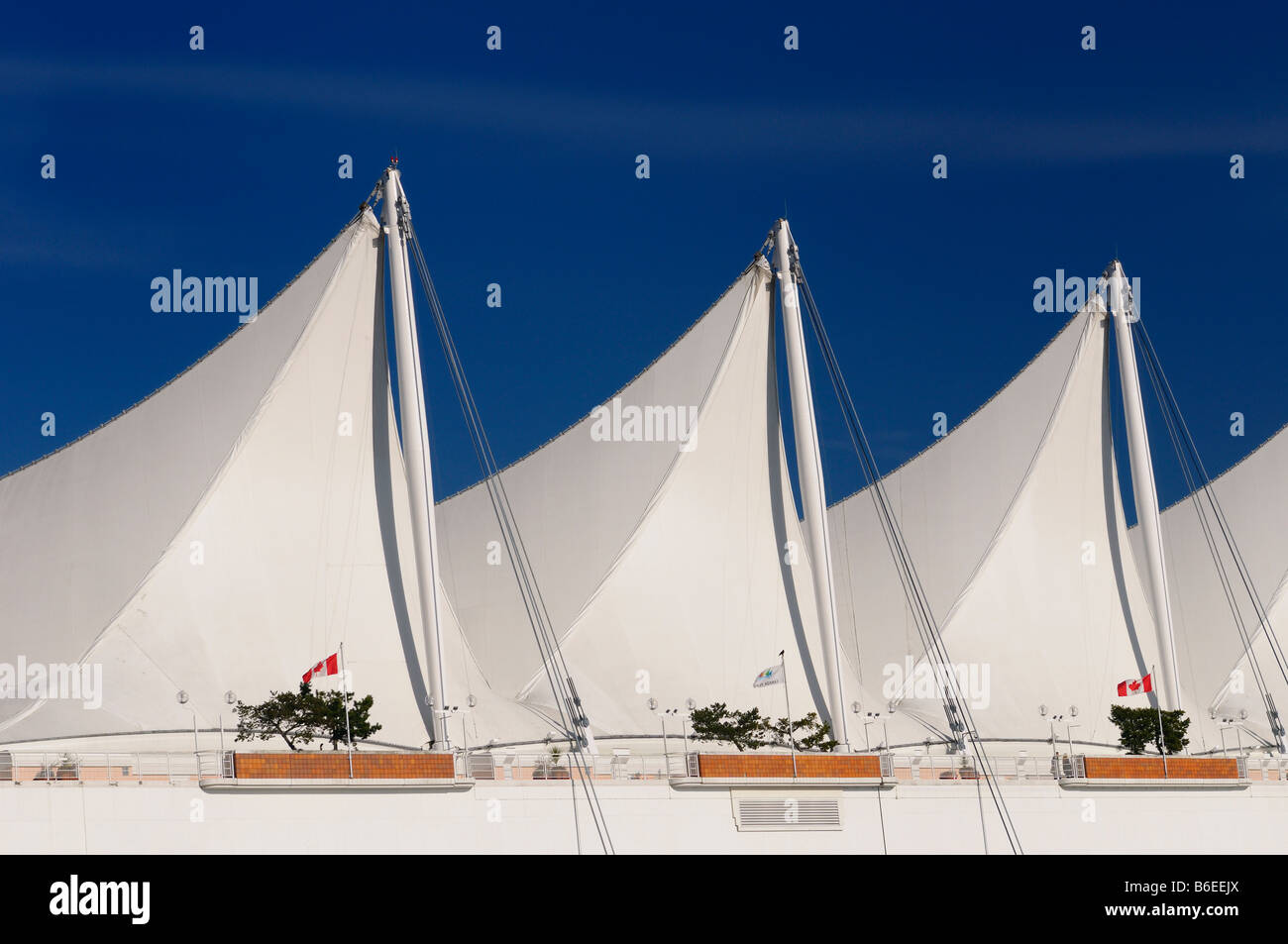 Abstract white sails Canada Place à Vancouver contre un ciel bleu avec des drapeaux du Canada British Columbia Canada Banque D'Images