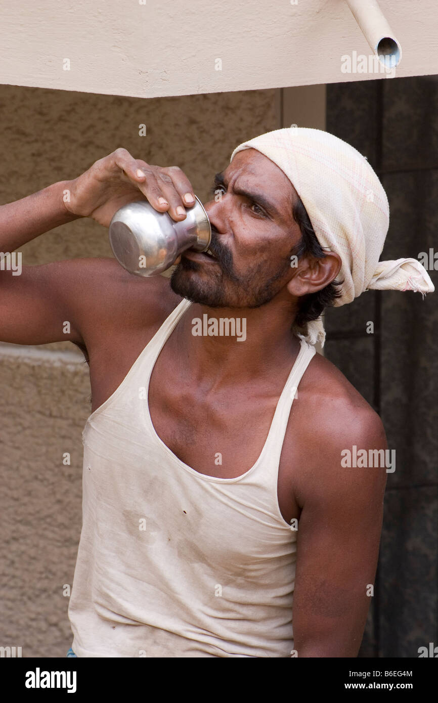 L'eau potable ouvrier indien épuisé Banque D'Images