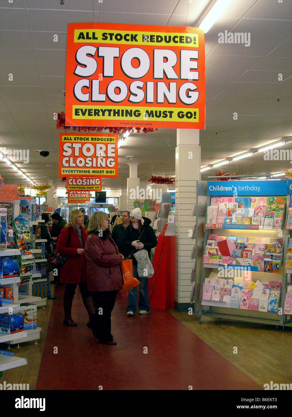 La chasse aux acheteurs pour Noël affaires au magasin Woolworths fermeture vente, Scarborough, Angleterre. Banque D'Images