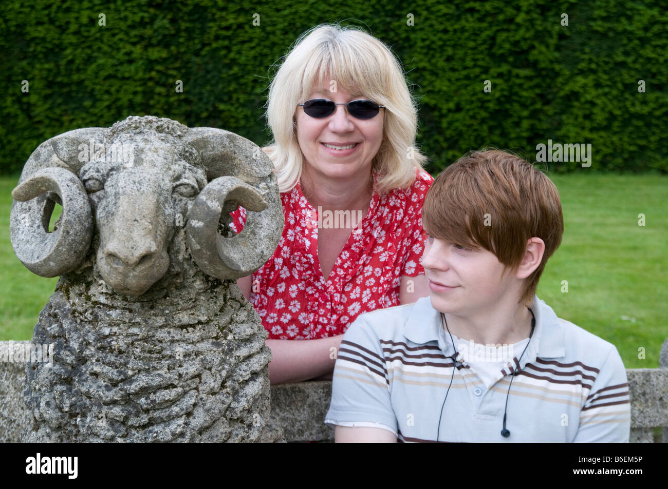 Teenage boy avec femme d'âge moyen s'assit à côté d'une pierre de ram Dorset England UK Banque D'Images