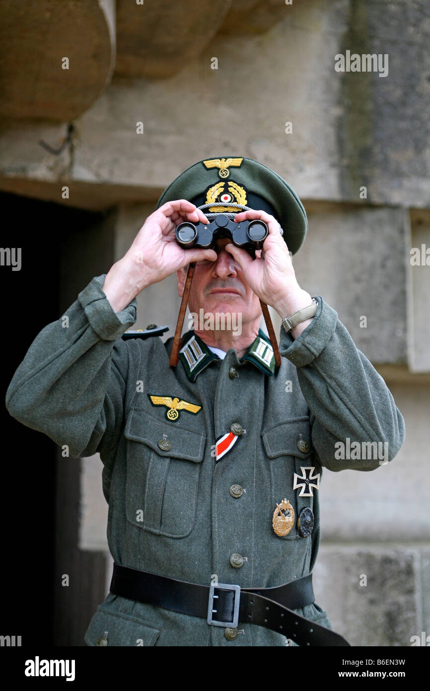 Un acteur vêtu comme un soldat officier allemand à la recherche sur la Manche, à partir d'un bunker allemand Jour J en Normandie France Banque D'Images