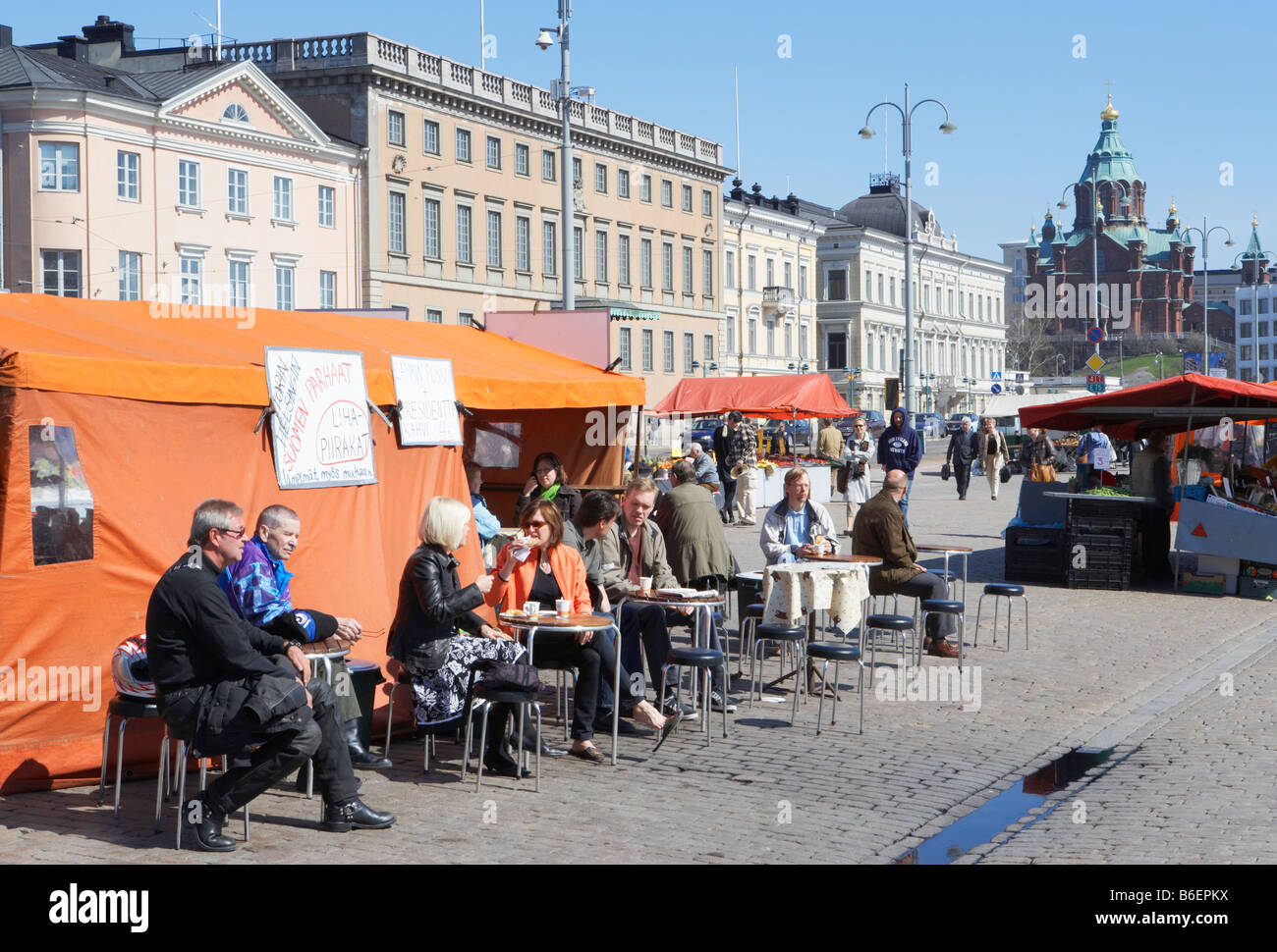 Les gens de manger et boire à l'un des étals de la place du marché, la cathédrale Uspenski en arrière-plan Helsinki Finlande Banque D'Images