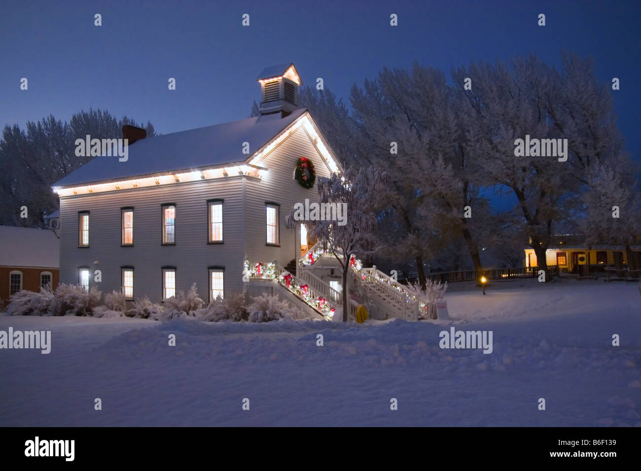 Une vieille église entourée de pionnier à l'époque de Noël Arbres enneigés dans Pioneer Village State Park à Salt Lake City Utah USA Banque D'Images