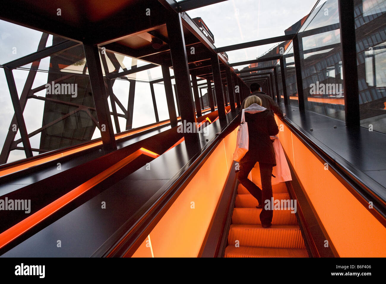 Escalator illuminé de Zeche Zollverein Site du patrimoine mondial avec une femme, de l'Allemagne, en Rhénanie du Nord-Westphalie, région de la Ruhr, à Essen Banque D'Images