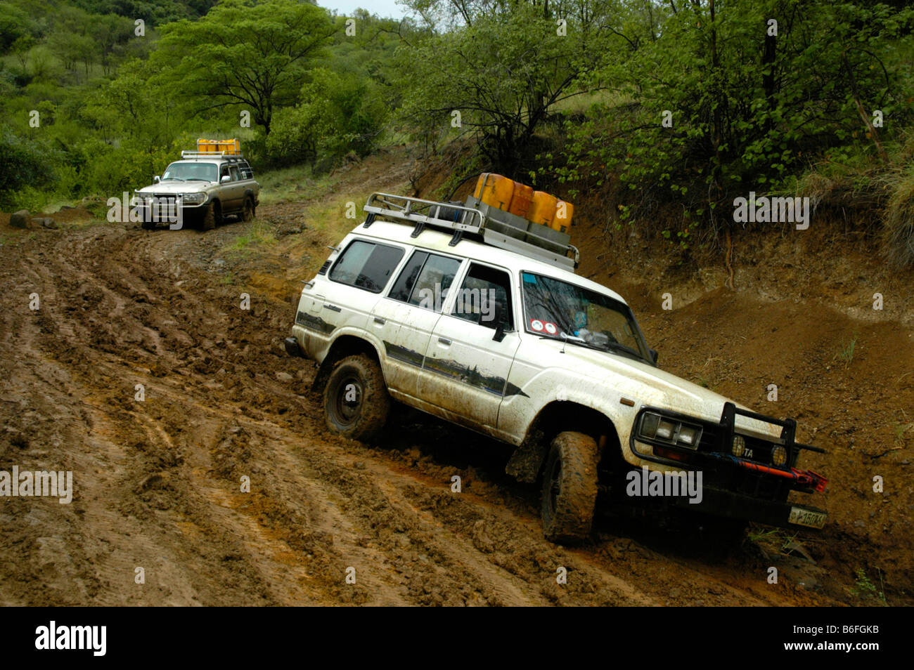 Deux Toyota Landcruiser glissant sur une route boueuse près de Jinka, Ethiopie, Afrique Banque D'Images