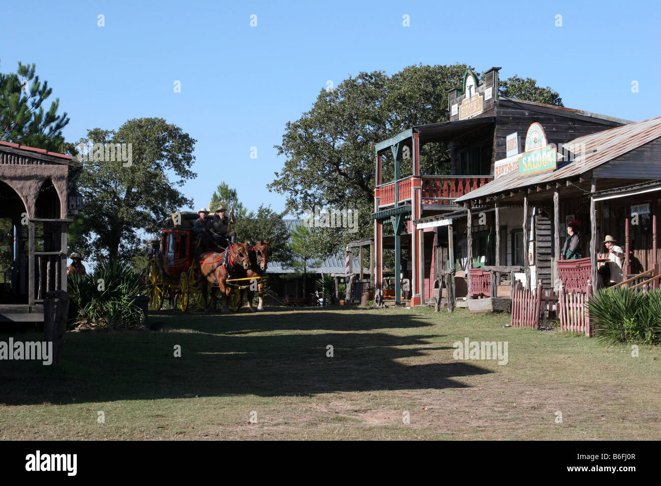 Deux cowboys conduisant le Butterfield Overland Stage Coach à travers une vieille ville de l'ouest Banque D'Images