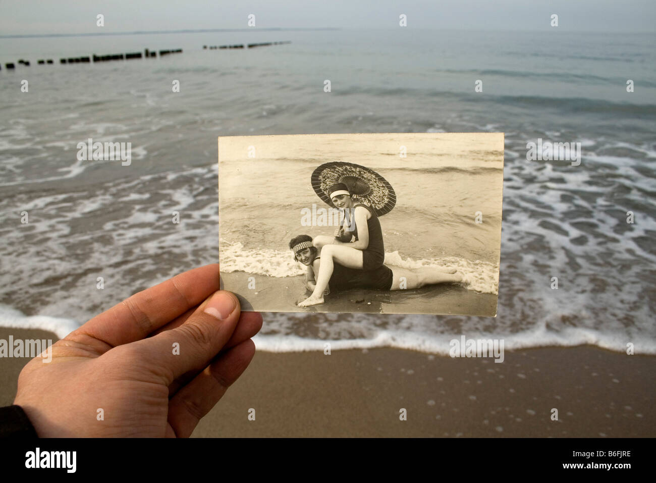 Main tenant une carte postale, ca. 1920, en face de la mer Baltique, hier et aujourd'hui Banque D'Images