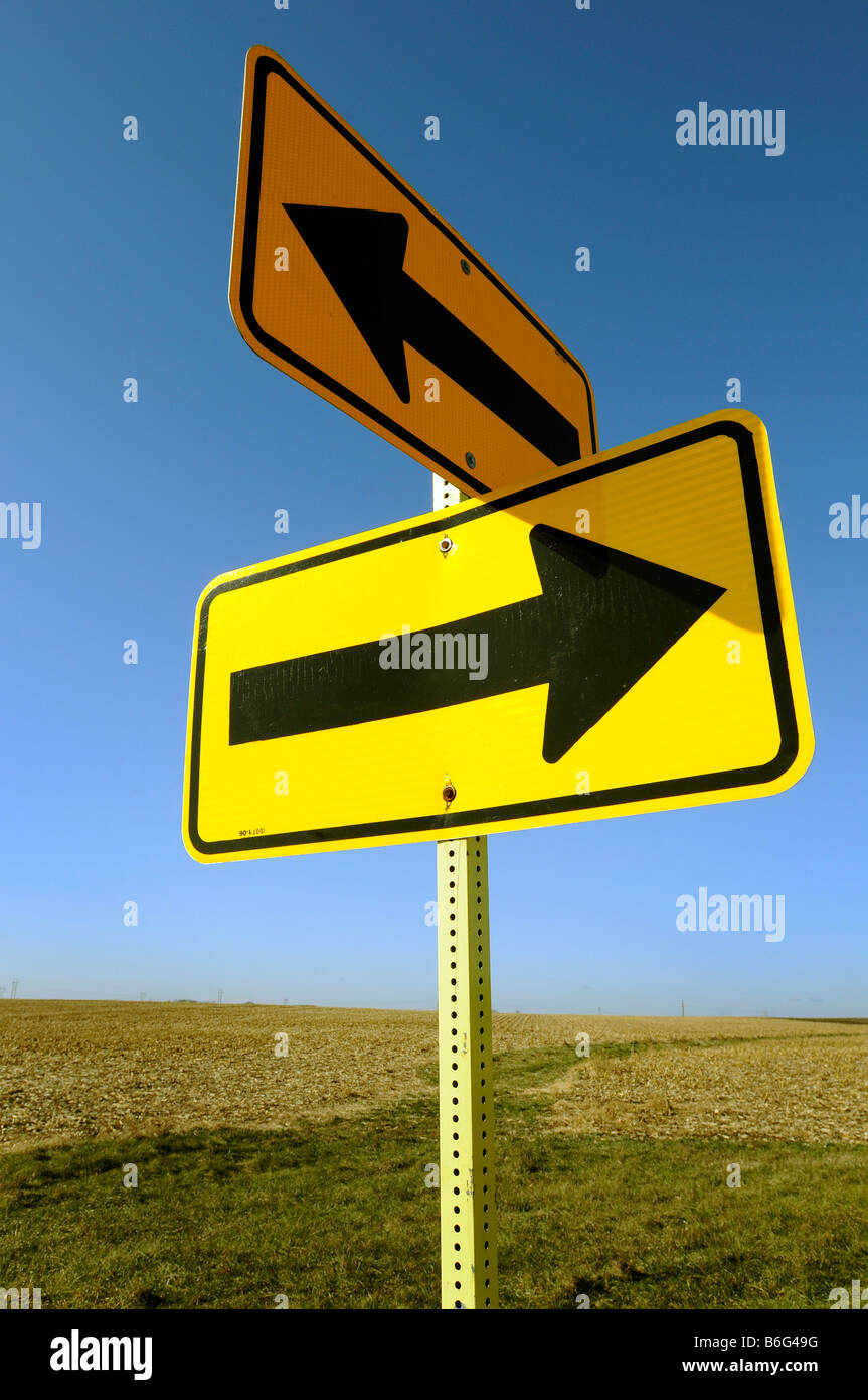 Flèches directionnelles sur la signalisation routière sur une route rurale Banque D'Images