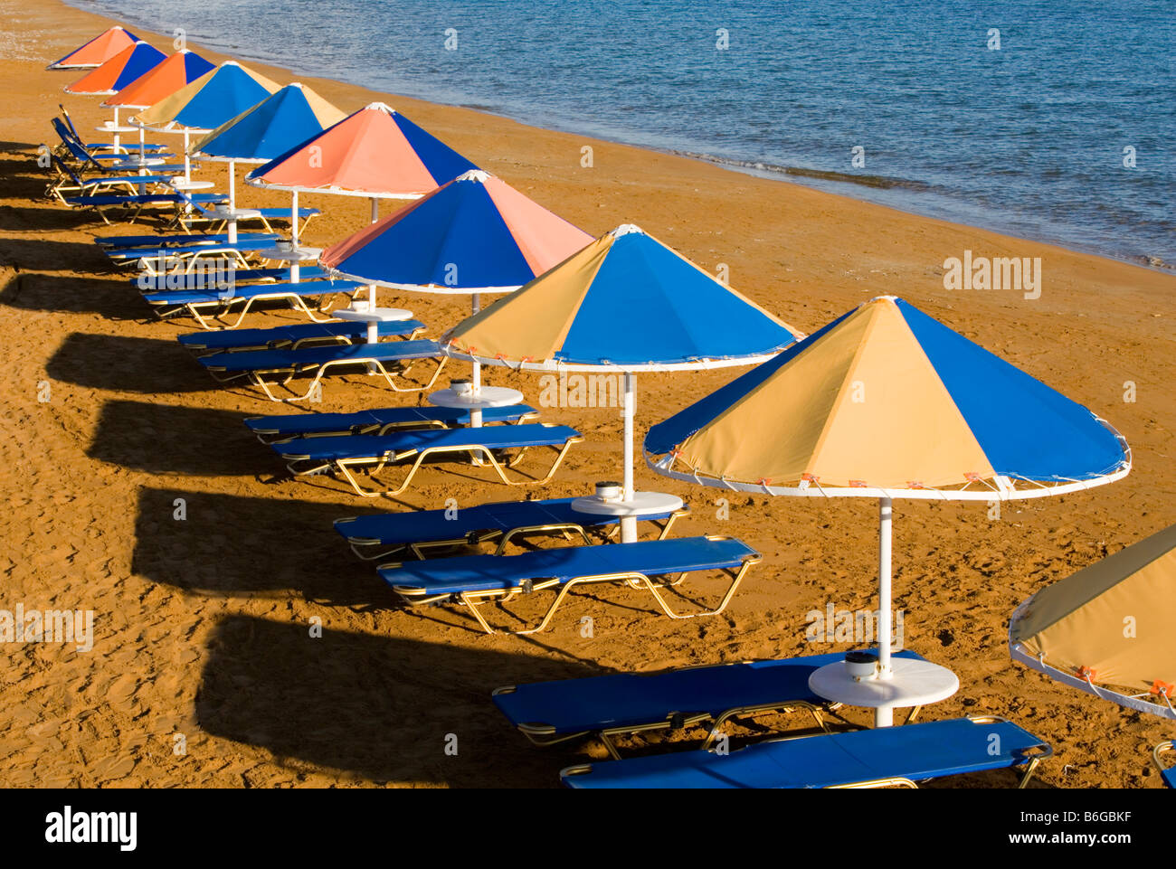 Xi parasols de plage soleil du soir en Grèce KEFALONIA Banque D'Images