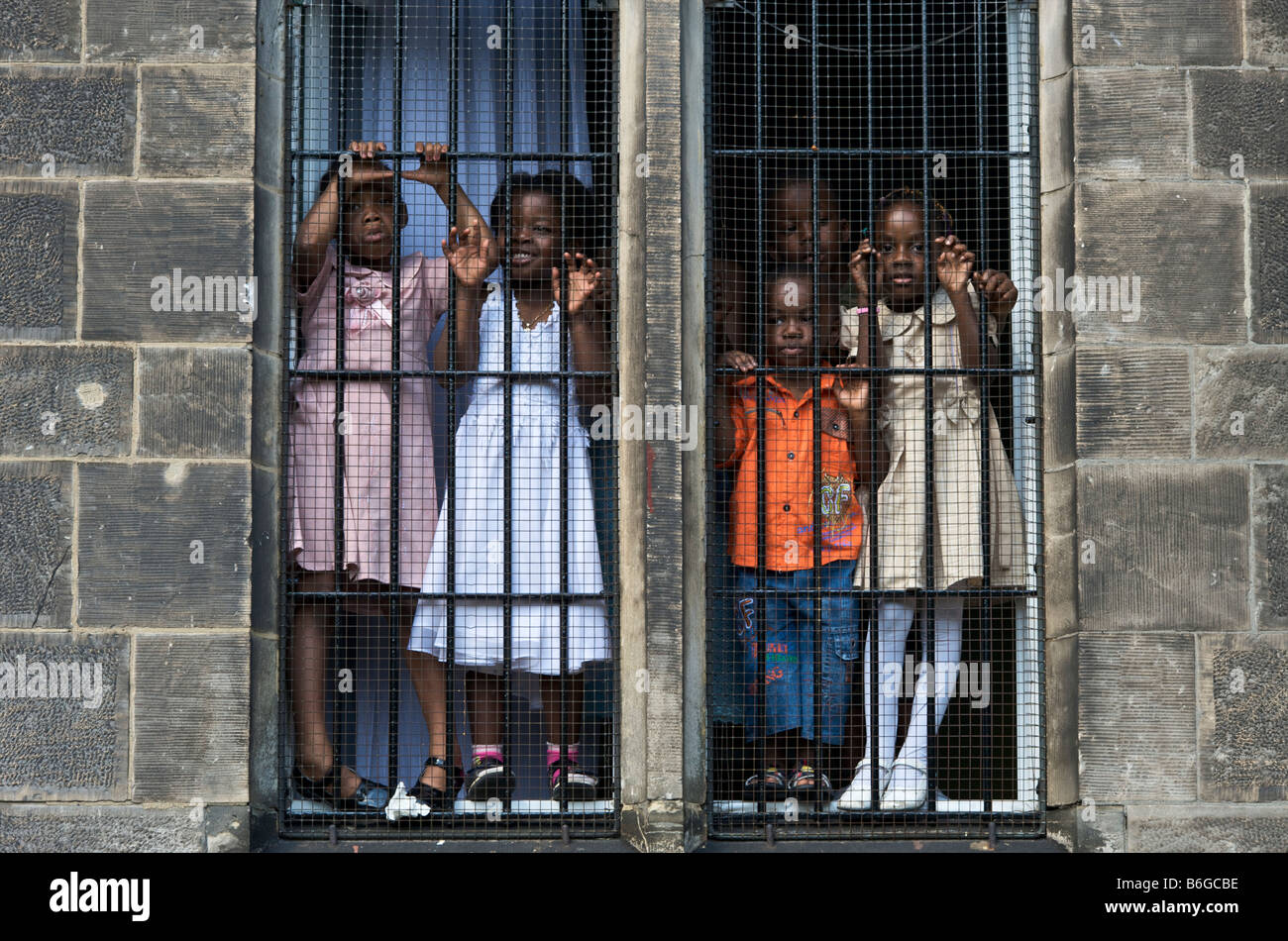 Black Kids Carnaval des Cultures regarder derrière la fenêtre barrée Banque D'Images