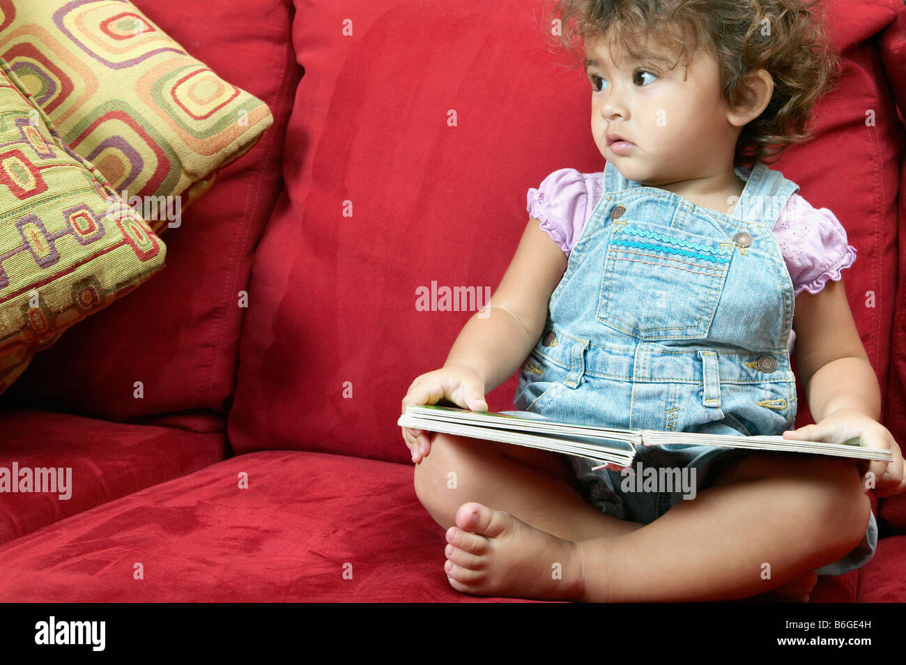 Petite fille de lire et regarder la télévision Banque D'Images