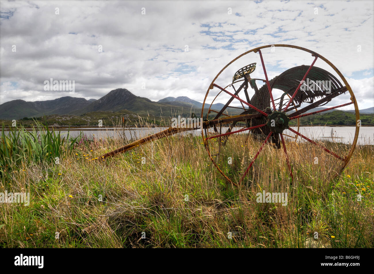 Connemara old abandoned farm machinery réflexion rural petits nuages blancs représentent l'eau claire les broches Twelve Bens Banque D'Images