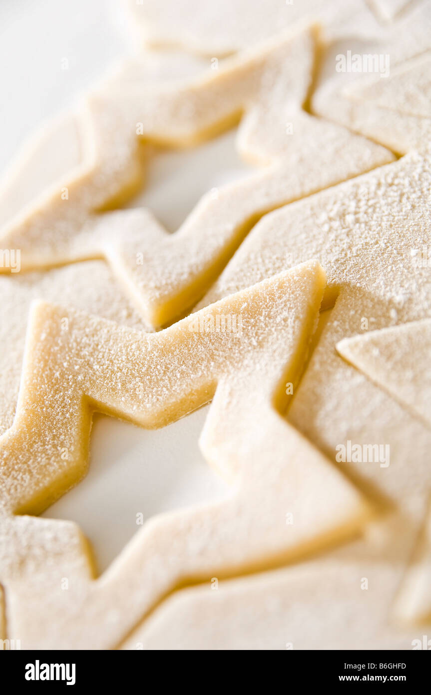 Biscuits au gingembre en forme d'étoile d'être éliminé avec l'emporte-pièce. Ensuite cuits et emballés dans des petites boîtes pour les cadeaux de Noël. Banque D'Images