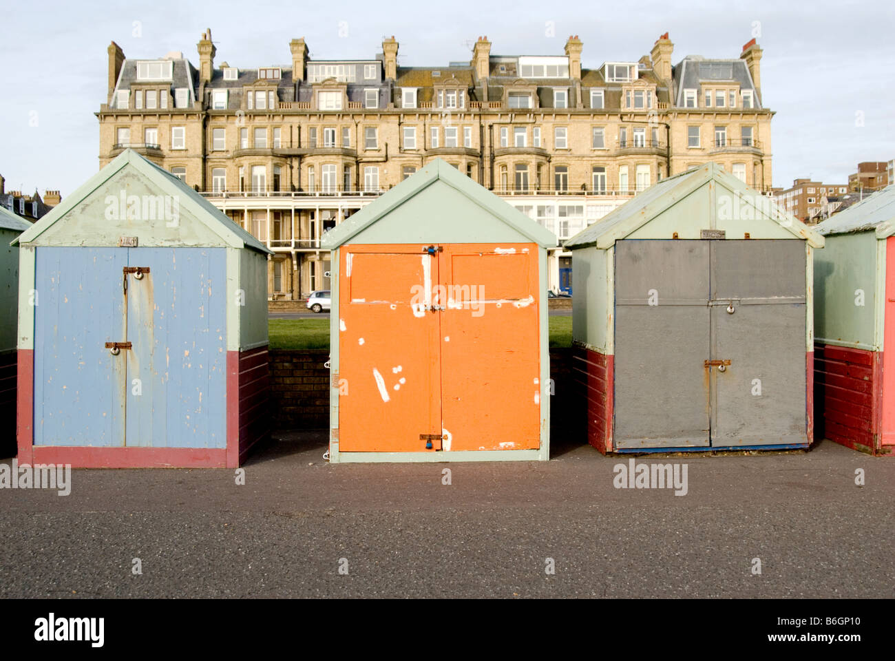 Une ligne de cabines de plage sur le front de mer de Brighton avec des bâtiments de Brighton dans l'arrière-plan Banque D'Images