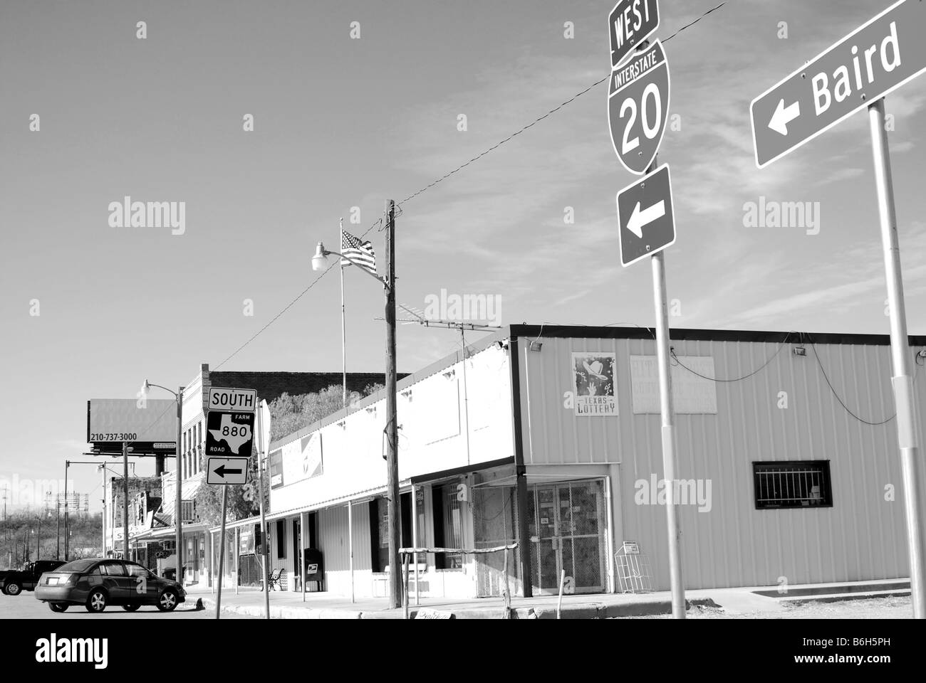 Image en noir et blanc de la signalisation routière pointant vers la gauche dans une petite ville du Texas de l'ouest Banque D'Images