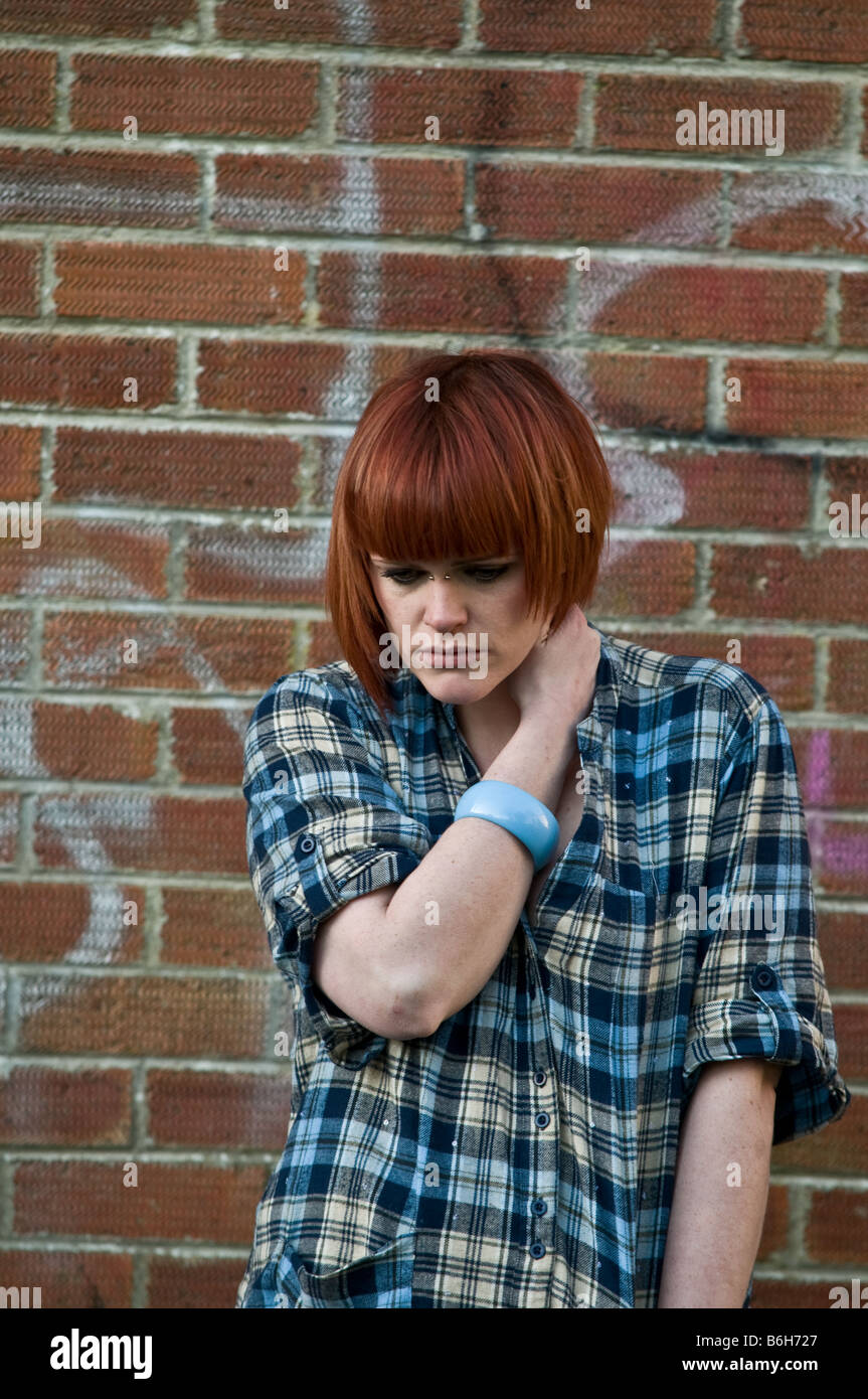 Jeune femme adolescente avec de courts cheveux rouges à la misérable triste solitaire seul déprimé et seul sans amis UK Banque D'Images