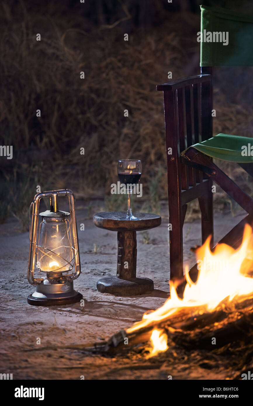 Détente à un feu de camp avec un verre de vin rouge Jack's Camp Makgadikgadi Pans, Botswana Banque D'Images