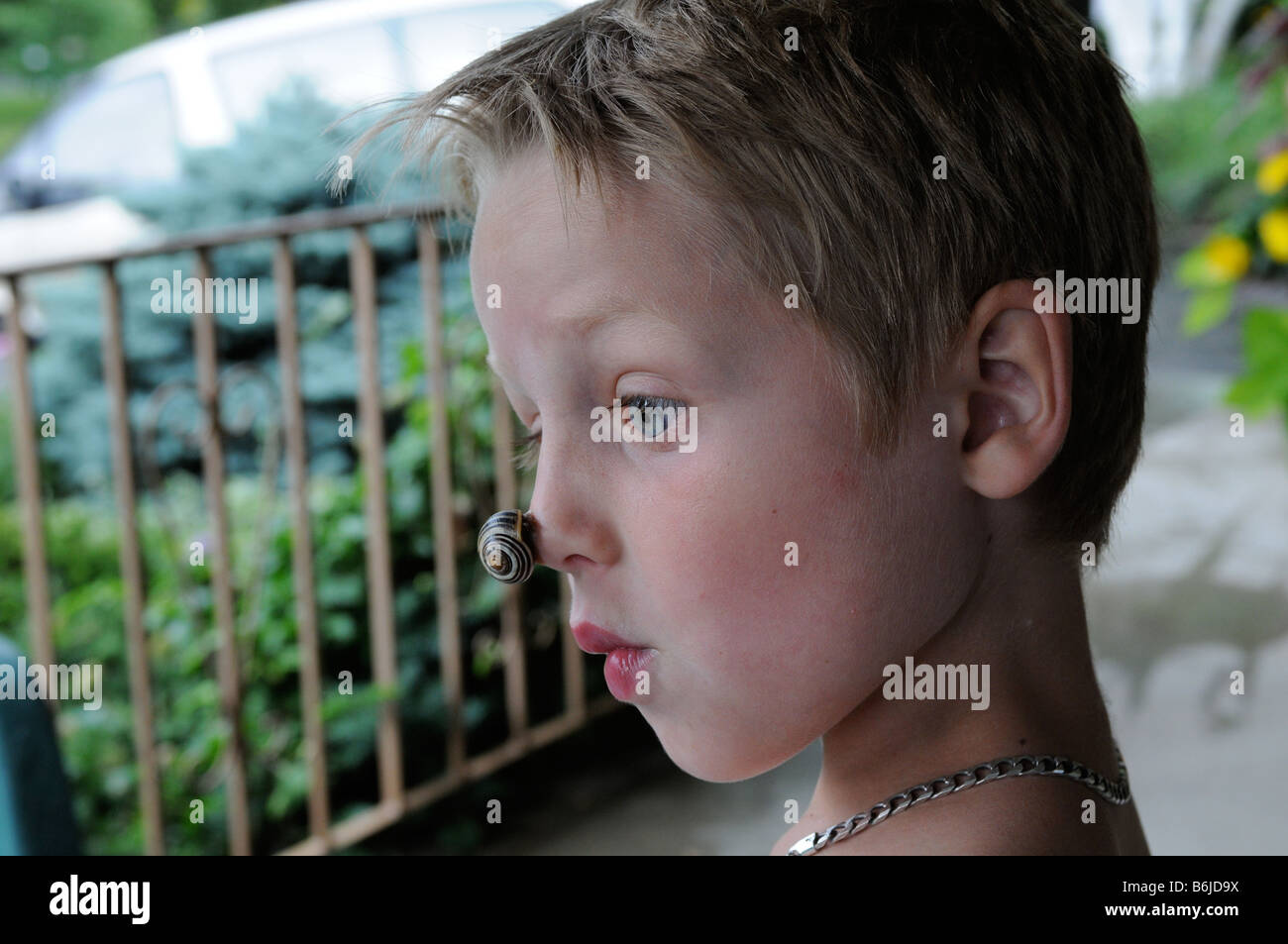 Un garçon avec un escargot sur son nez, nature's version d'un nez de clown Banque D'Images