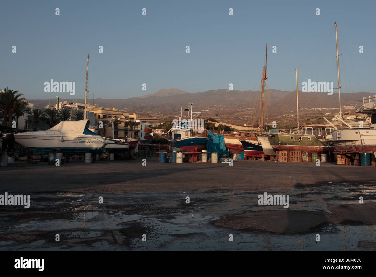 Bateaux en cale sèche avec le sommet du mont Teide derrière au crépuscule à Playa San Juan Tenerife Espagne Banque D'Images