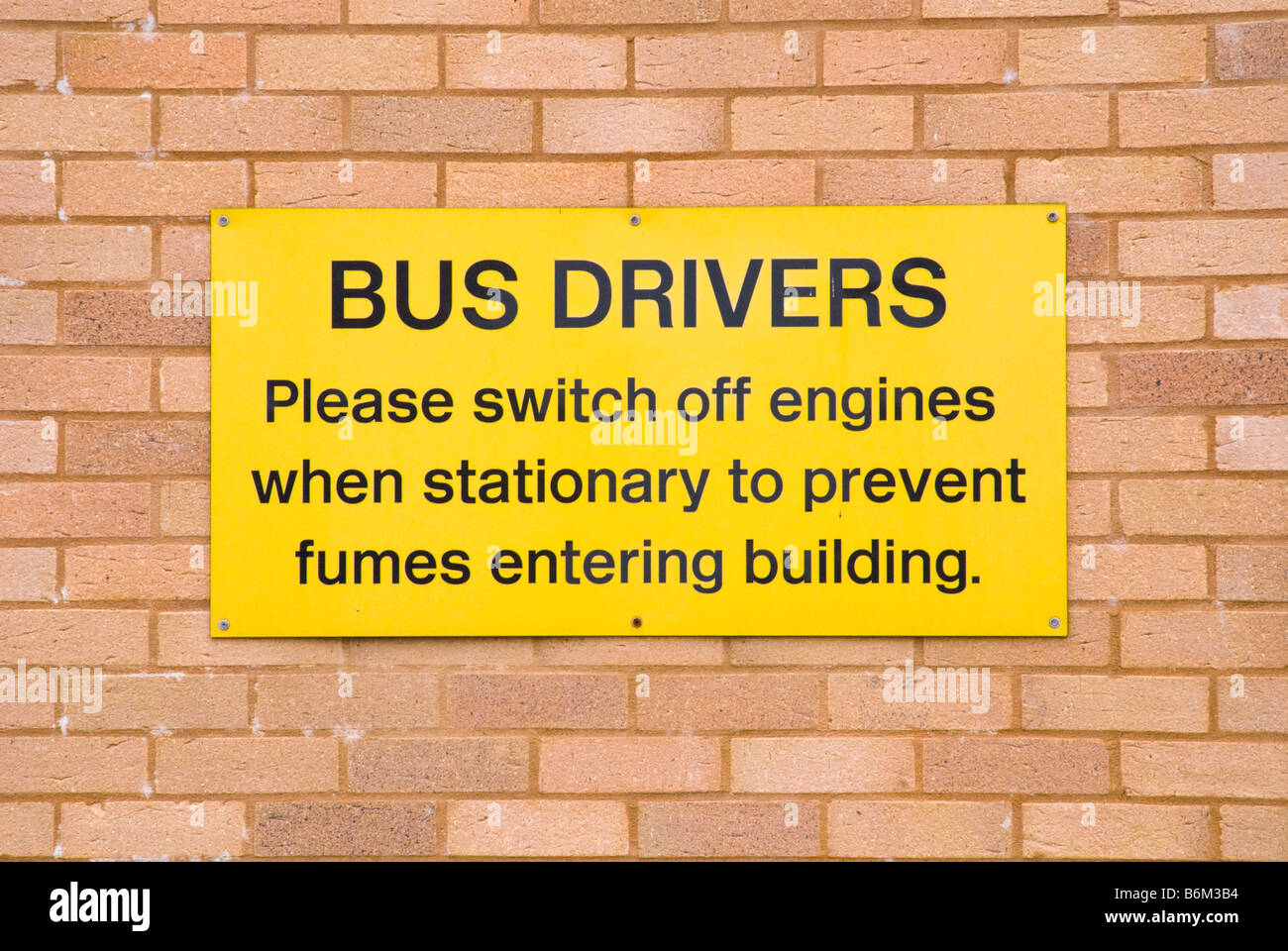 Veuillez couper les conducteurs d'autobus à l'arrêt des moteurs pour empêcher l'entrée des fumées building signe sur uk wall Banque D'Images