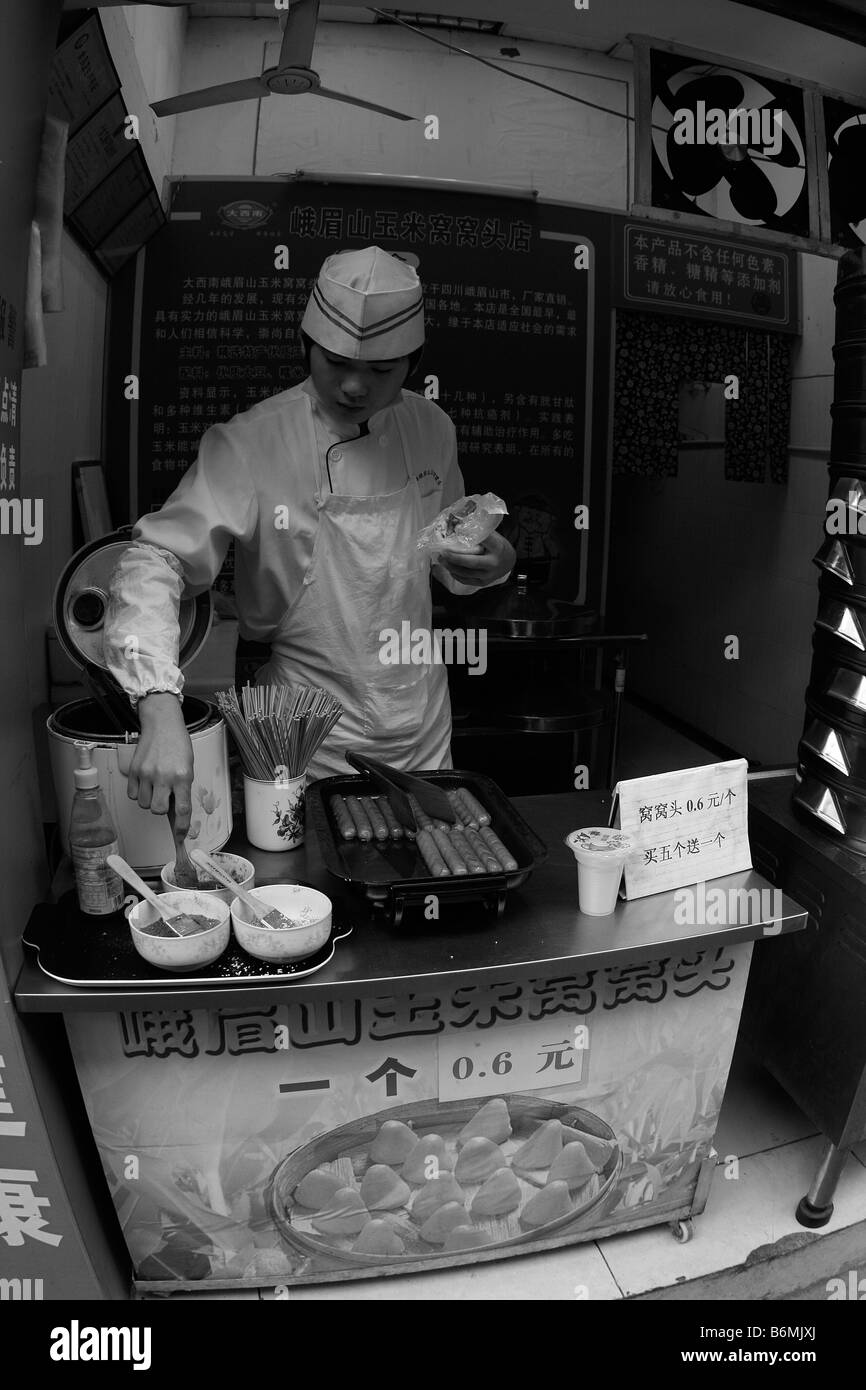 Un jeune homme prépare le petit-déjeuner dans le premier froid matin d'hiver pour en passant par les navetteurs sur une rue latérale et Guangdong Guangzhou Banque D'Images