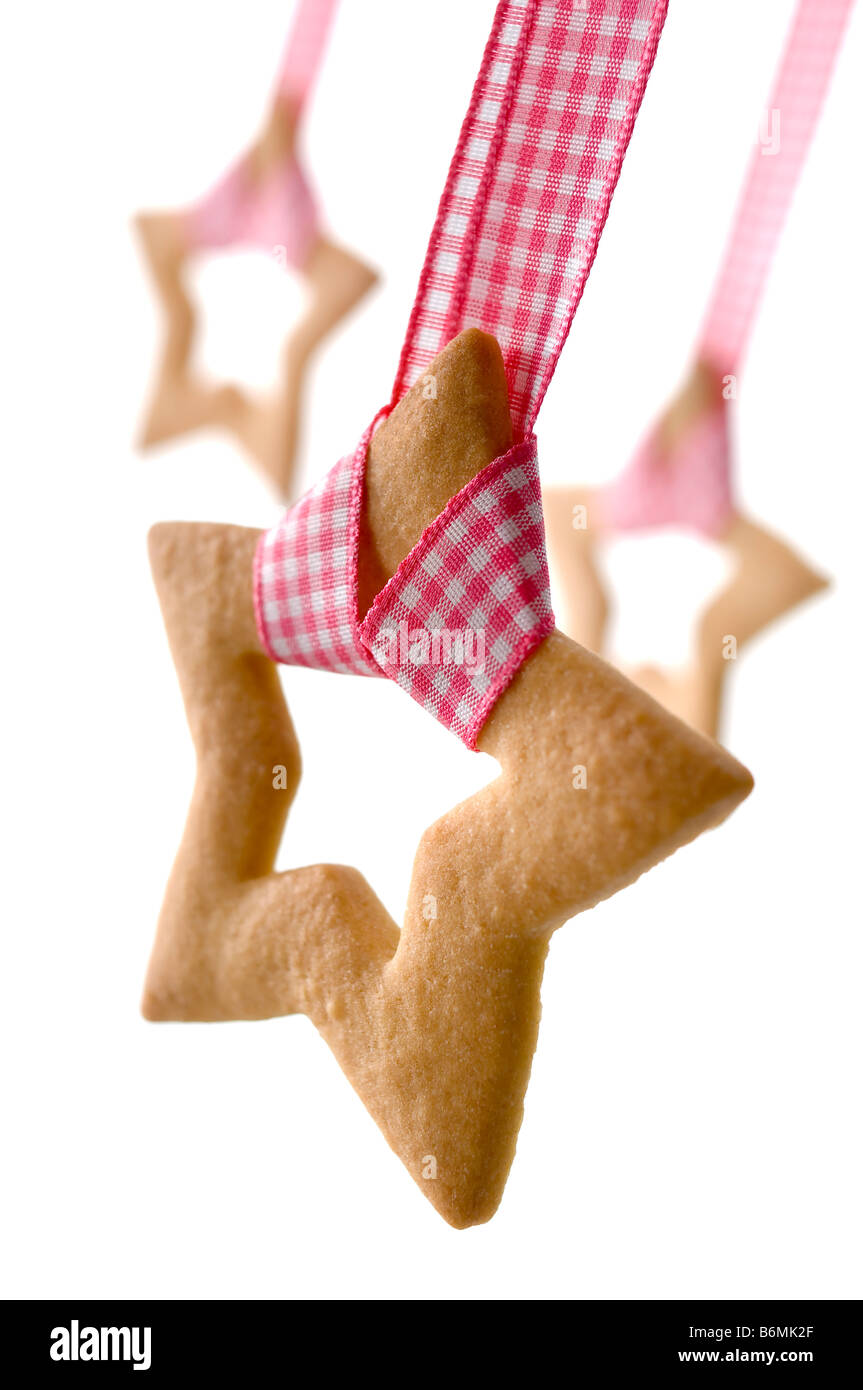 Des biscuits en forme d'étoile raccroché sur ruban vichy rose de couleur à utiliser comme décorations de Noël. Banque D'Images